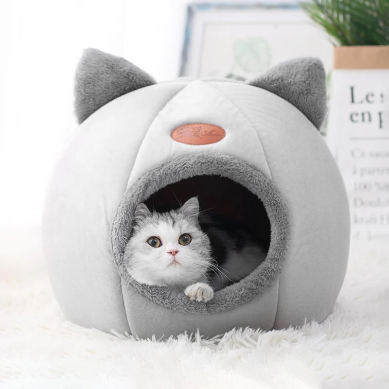 Cat inside cozy cave-style pet bed with ear design