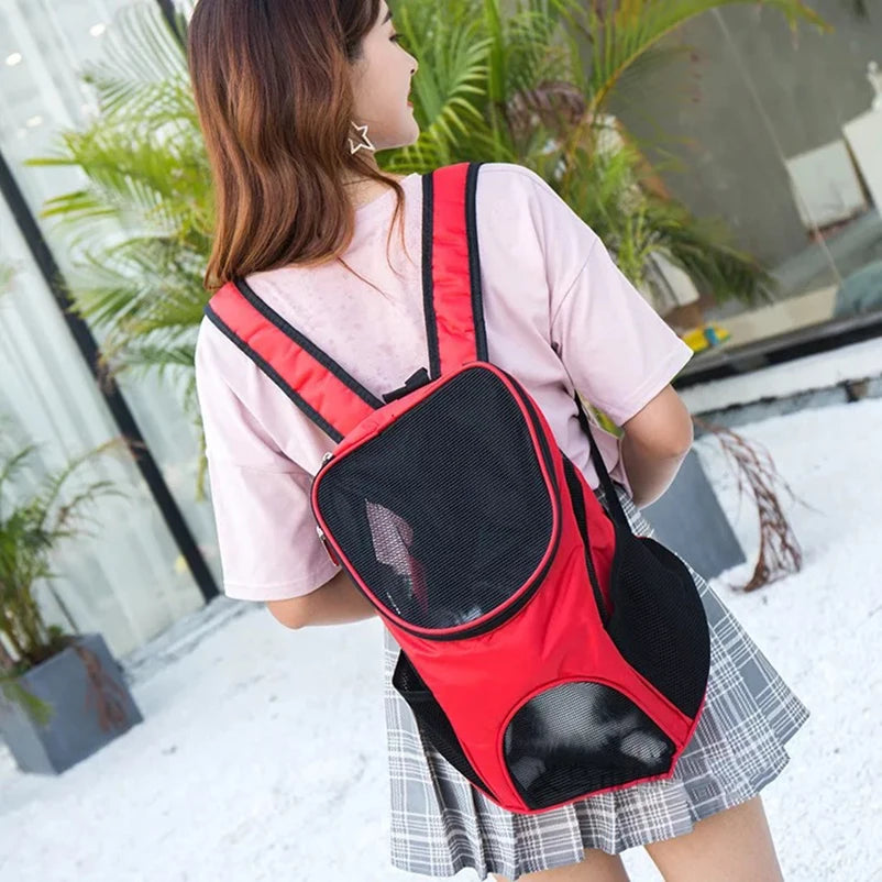 Woman carrying red pet travel backpack with small dog