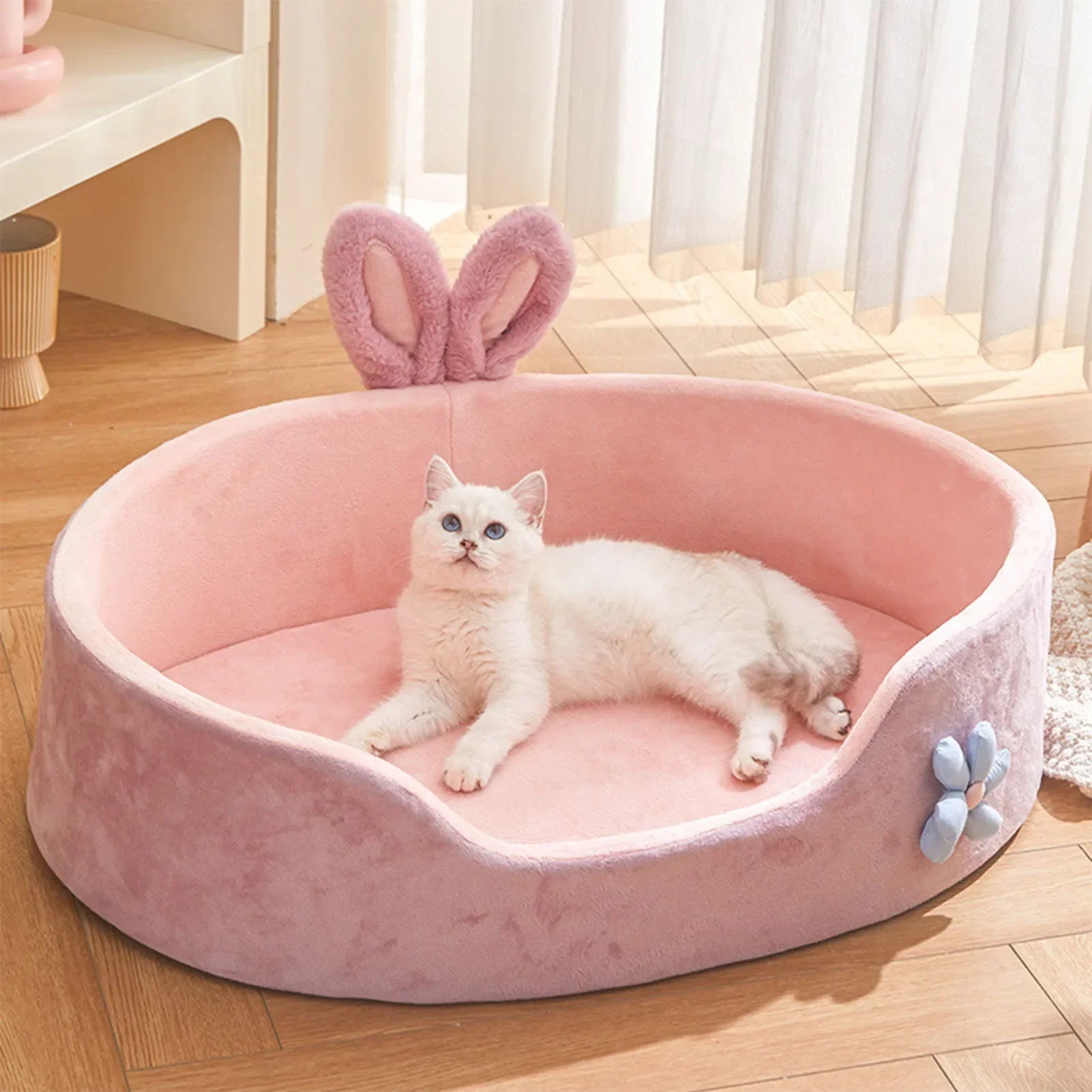White puppy lying inside cozy pink bed – indoor photo