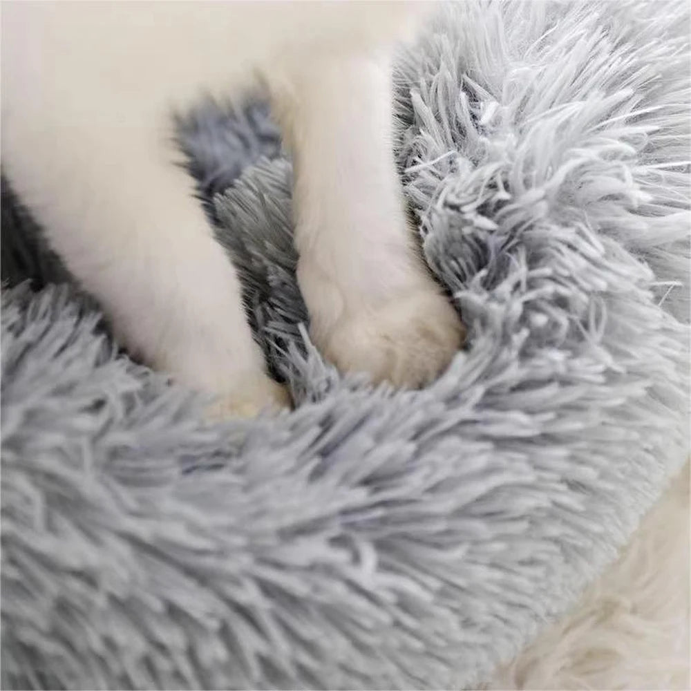 Small puppy resting in a round plush pet nest bed