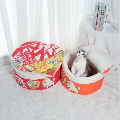 Cat sleeping inside noodle cup shaped plush pet bed